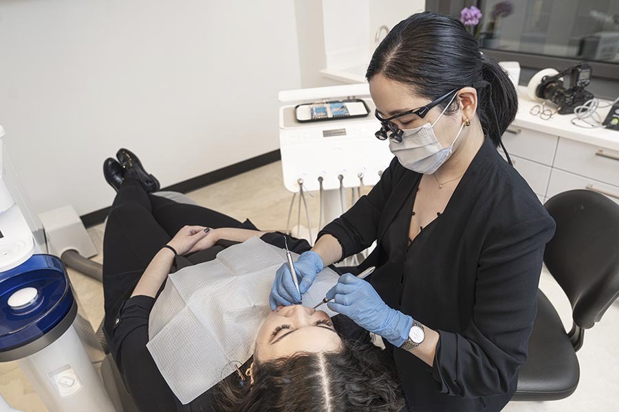 Dentist treating broken tooth during chairside procedure in Midtown East NYC dental office