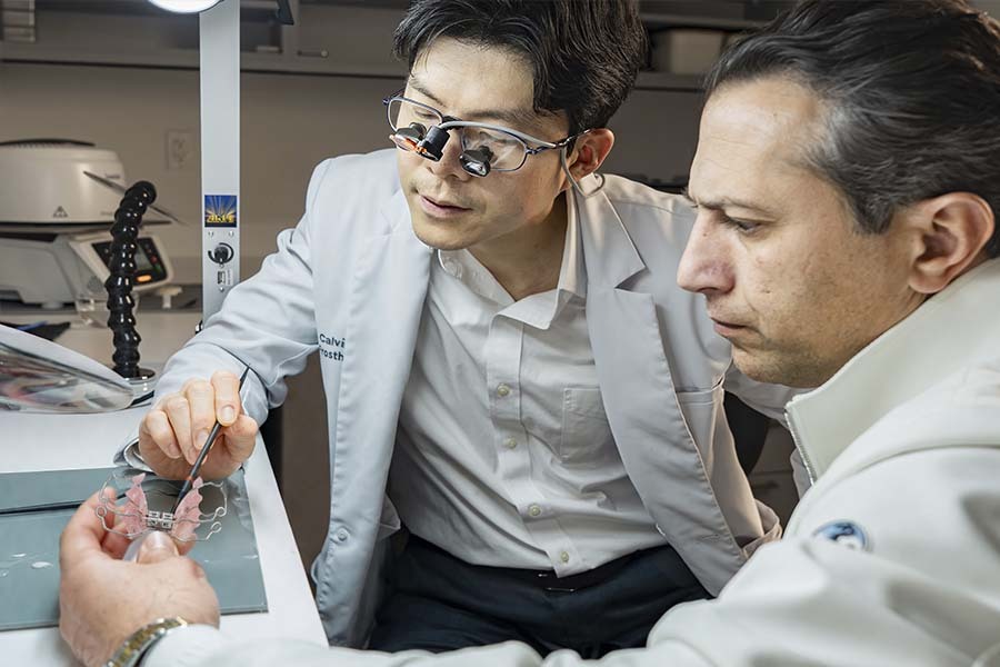 Dentists reviewing dental appliance for palate expander treatment planning in Midtown East NYC