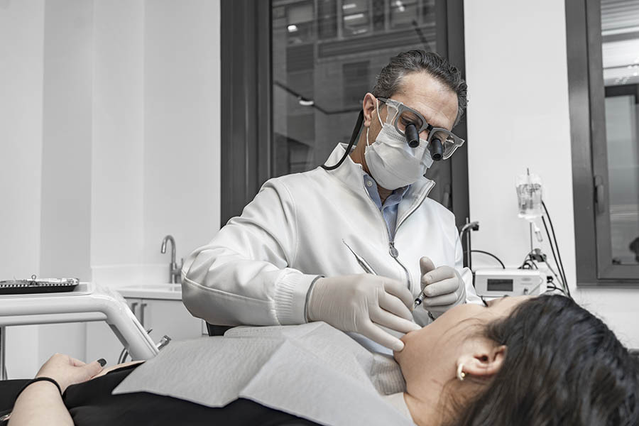 Periodontitis treatment in Midtown East NYC with dentist evaluating gum disease and performing clinical care