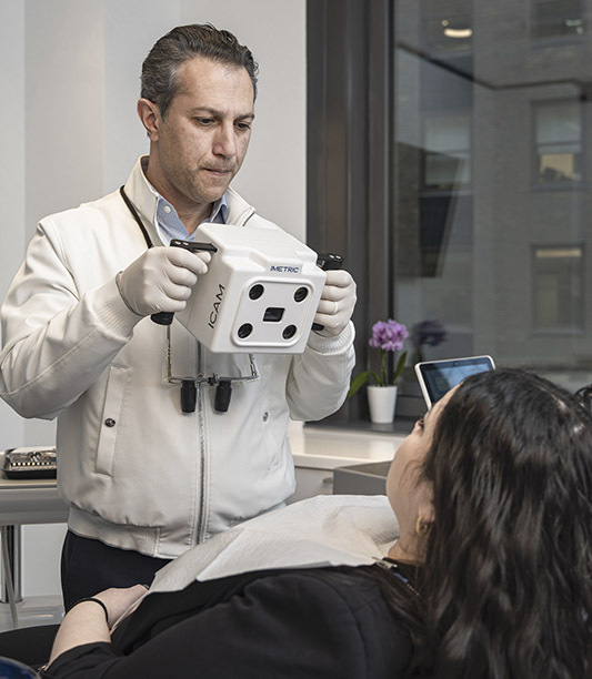 Dentist using intraoral scanner to create 3D digital image for same day dental crown in Midtown Manhattan NYC